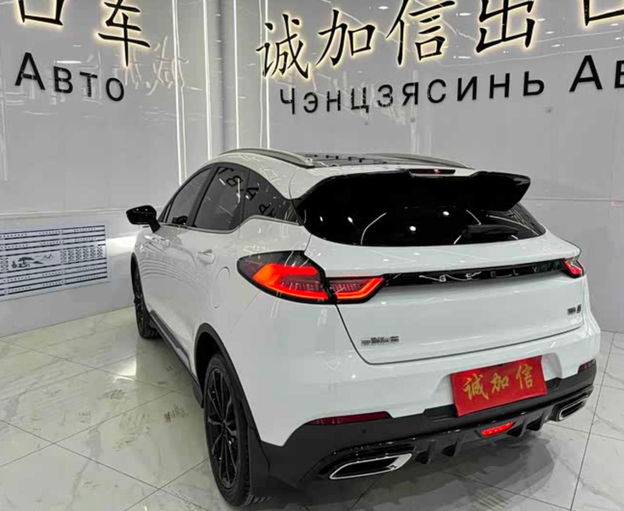 Задняя часть белого Geely Emgrand S: фонари, спойлер, шильдик GEELY, красная табличка дилера на бампере